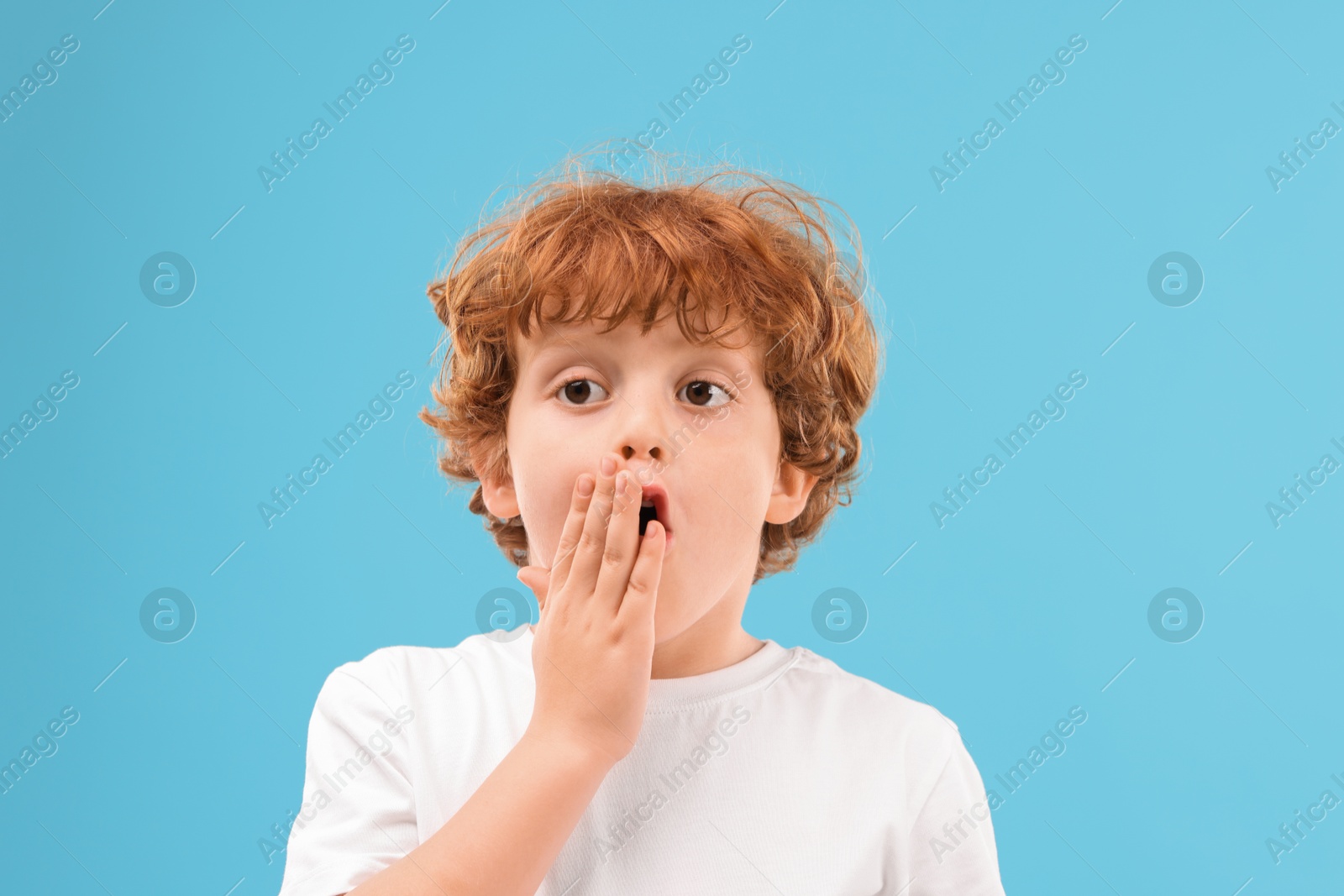 Photo of Portrait of emotional little boy on light blue background