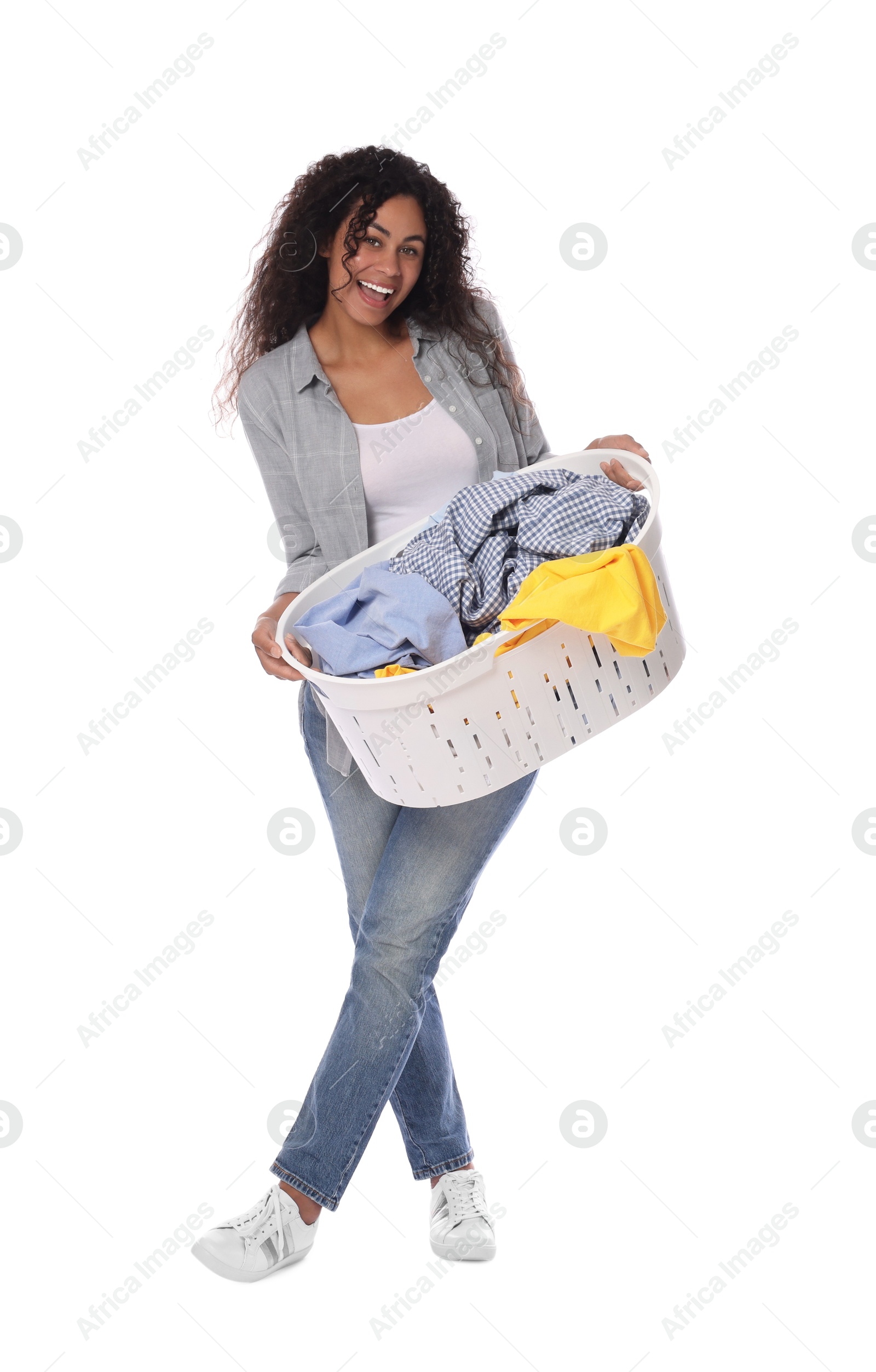 Photo of Happy woman with basket full of laundry on white background