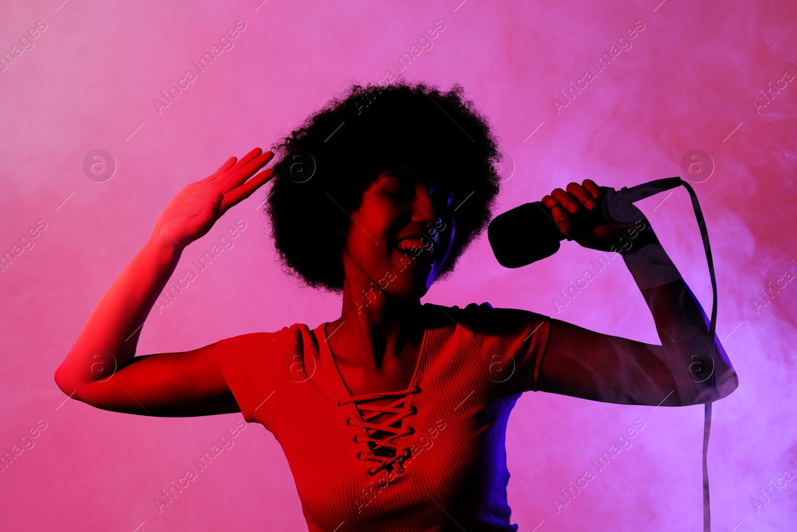 Image of Singer with microphone in neon lights on stage