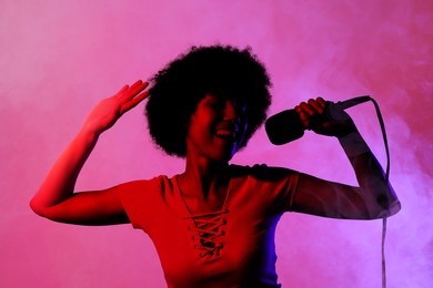 Image of Singer with microphone in neon lights on stage