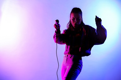 Image of Singer with microphone in neon lights on stage