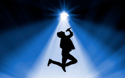 Image of Silhouette of singer on stage in spotlight
