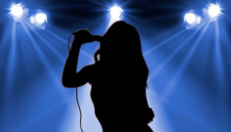 Silhouette of singer on stage in spotlights. Banner design