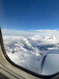 Photo of Beautiful blue sky with fluffy clouds, view from plane window