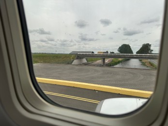 Photo of View on runway and surroundings through plane window