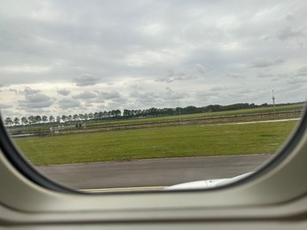 Photo of View on runway and surroundings through plane window