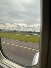 Photo of View on runway and surroundings through plane window