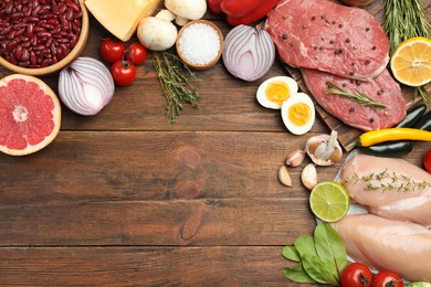 Photo of Flat lay composition with fresh meat and other products on wooden table, space for text. Balanced diet