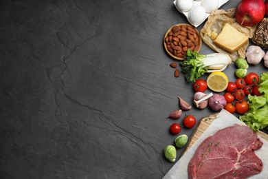 Photo of Flat lay composition with fresh meat and other products on black table, space for text. Balanced diet