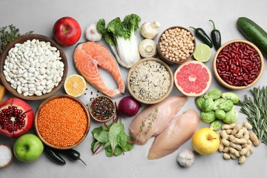 Flat lay composition with fresh meat and other products for balanced diet on light grey table