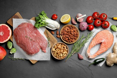 Photo of Flat lay composition with fresh meat and other products for balanced diet on black table