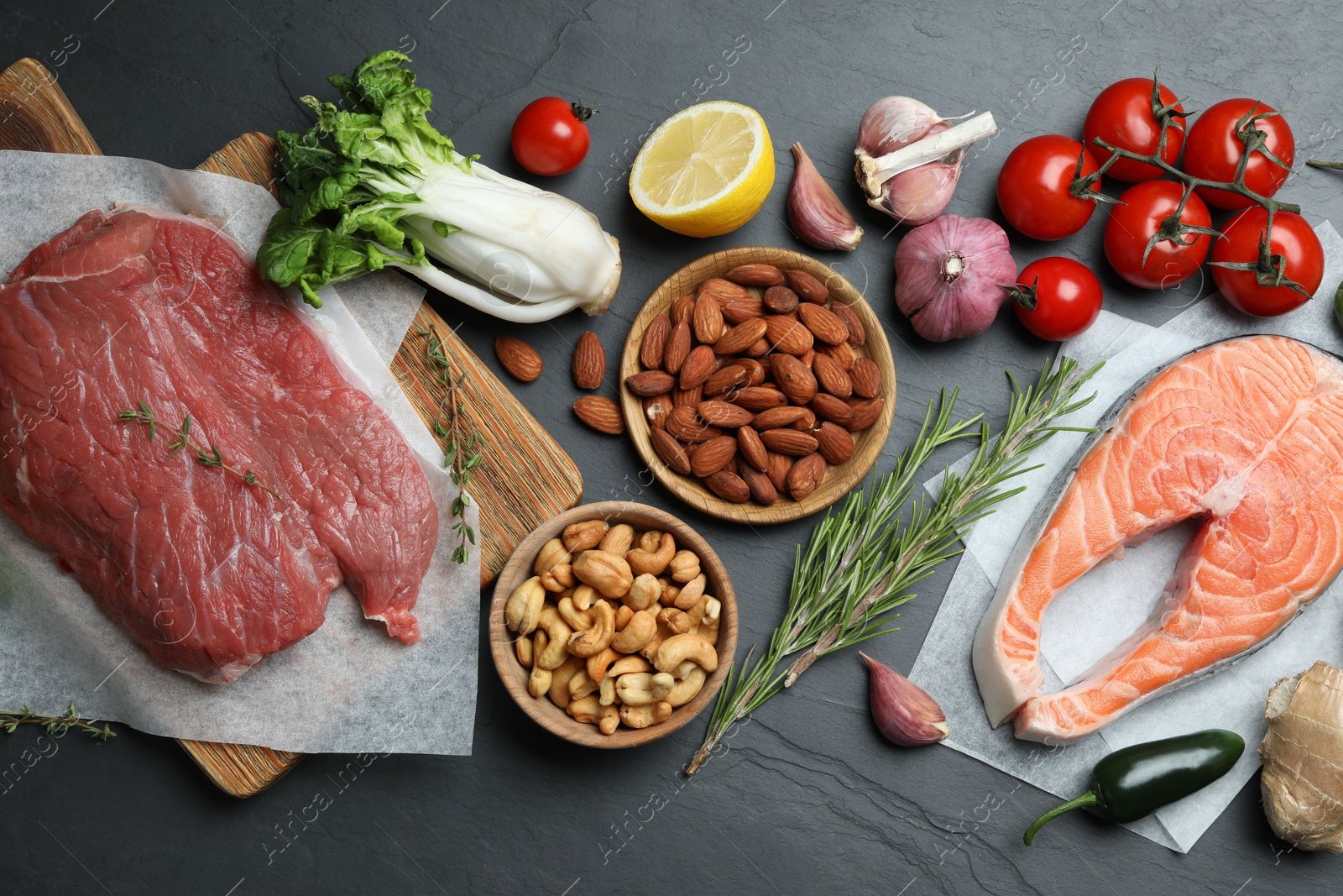 Photo of Flat lay composition with fresh meat and other products for balanced diet on black table