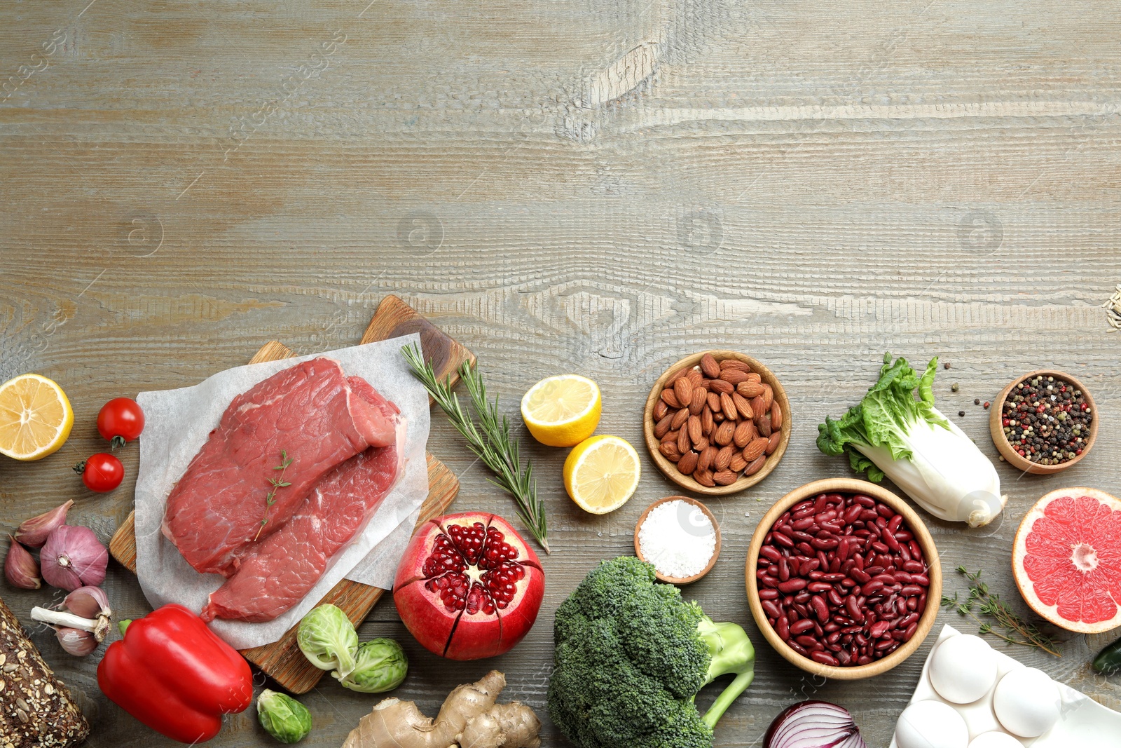 Photo of Flat lay composition with fresh meat and other products on wooden table, space for text. Balanced diet