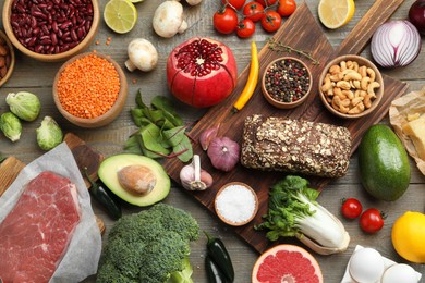 Flat lay composition with fresh meat and other products for balanced diet on wooden table