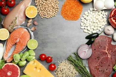 Photo of Flat lay composition with fresh meat and other products on grey table, space for text. Balanced diet