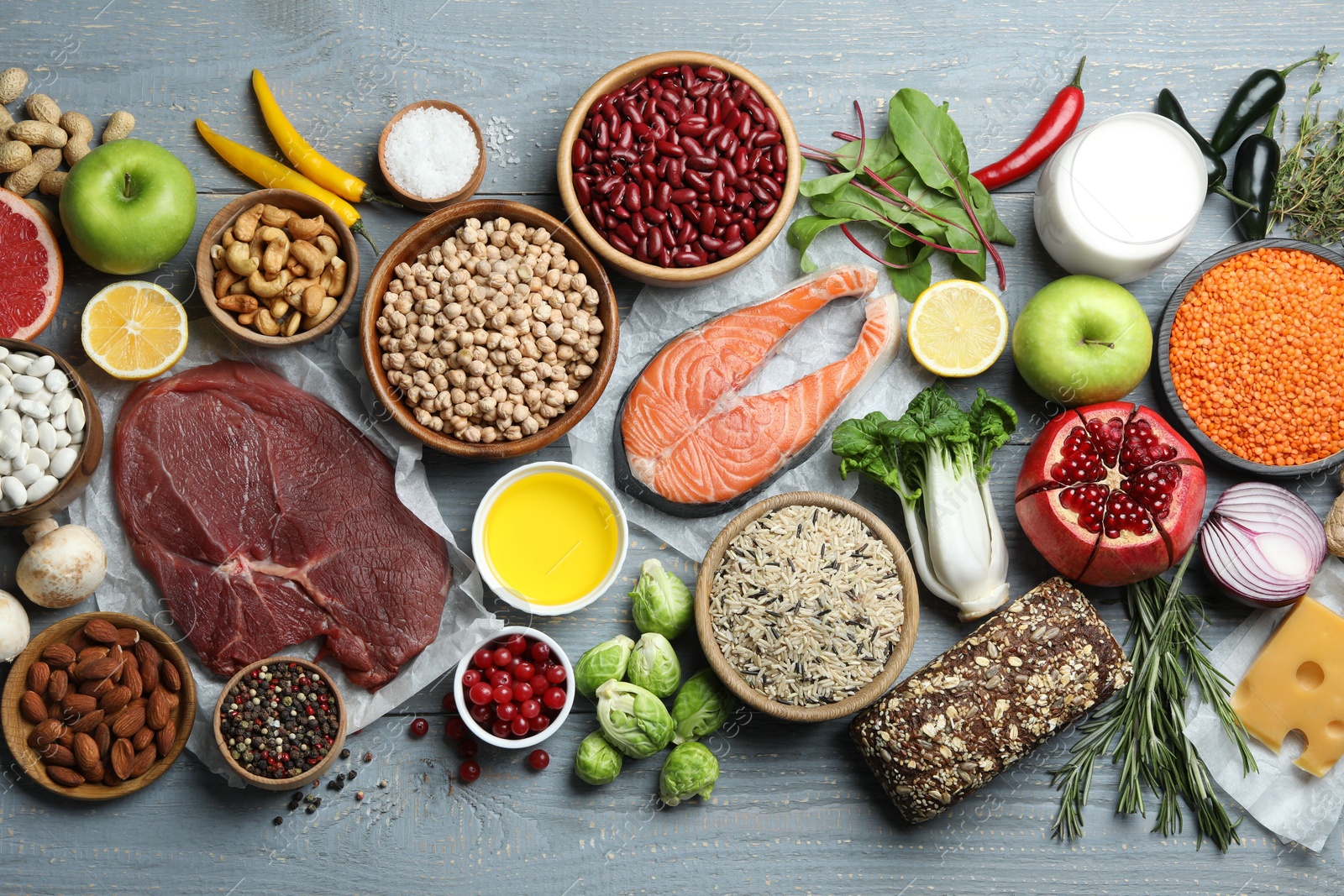 Photo of Flat lay composition with fresh meat and other products for balanced diet on grey wooden table