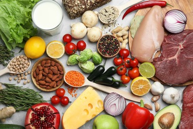 Flat lay composition with fresh meat and other products for balanced diet on grey marble table