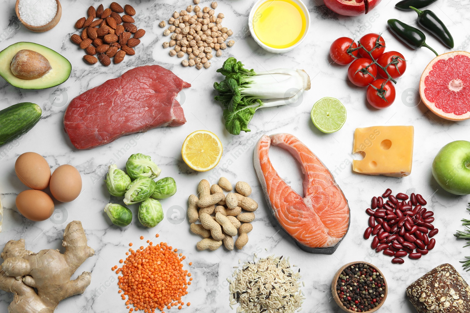 Photo of Flat lay composition with fresh meat and other products for balanced diet on white marble table