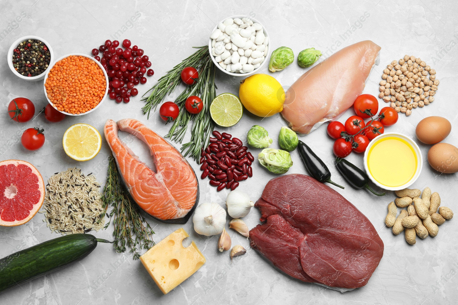 Photo of Flat lay composition with fresh meat and other products for balanced diet on grey marble table