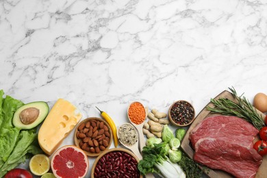 Photo of Flat lay composition with fresh meat and other products on white marble table, space for text. Balanced diet