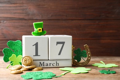 Photo of Composition with block calendar on wooden table. St. Patrick's Day celebration