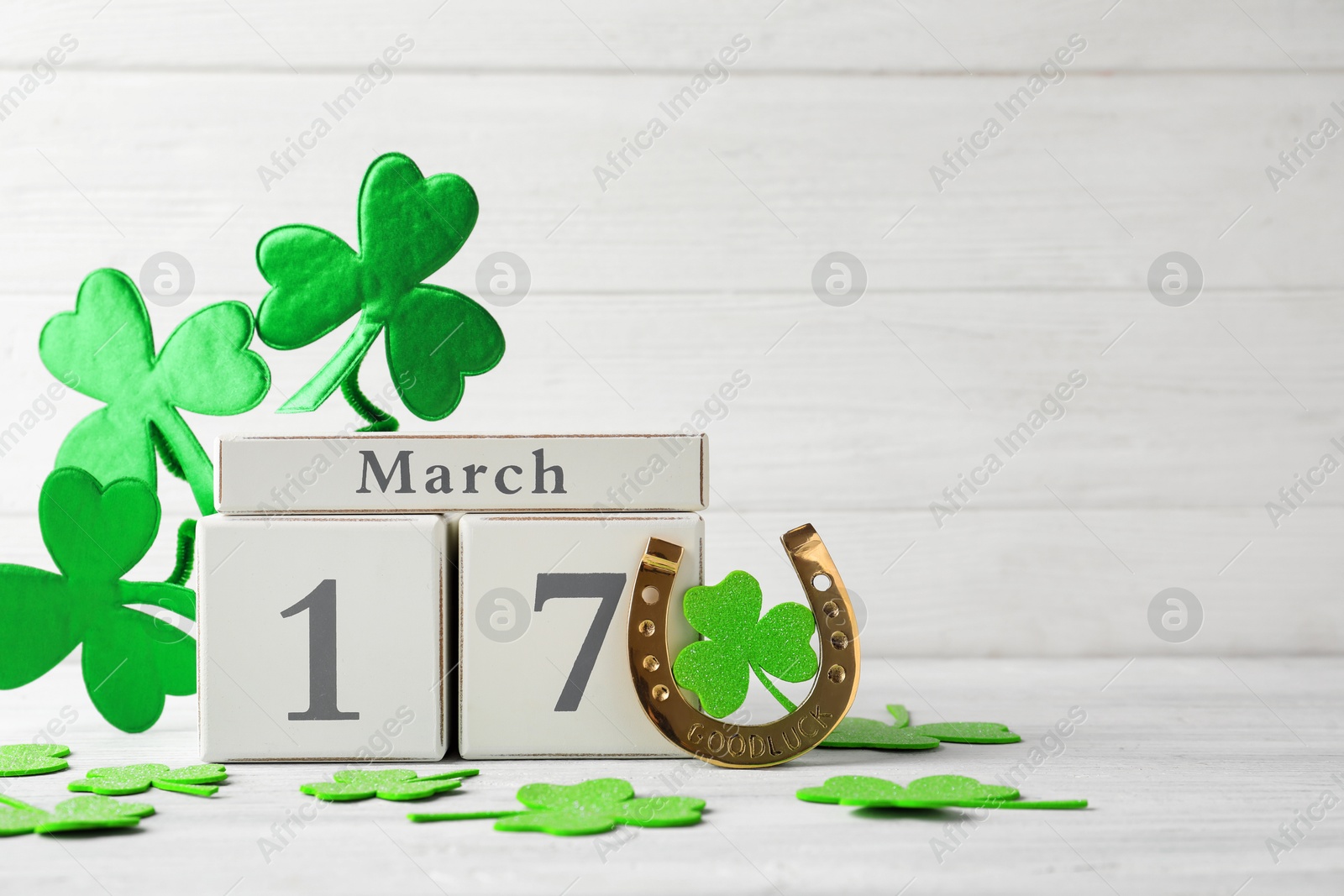 Photo of Composition with block calendar on white wooden table, space for text. St. Patrick's Day celebration