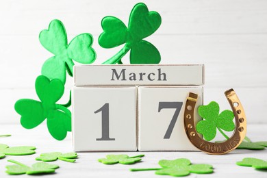 Photo of Composition with block calendar on white wooden table. St. Patrick's Day celebration