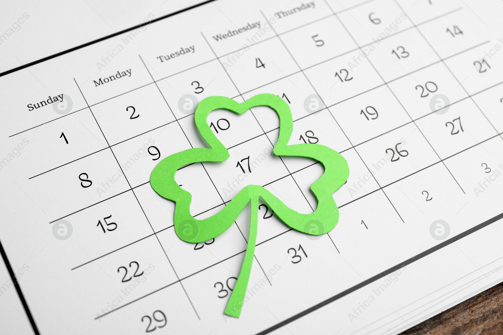 Photo of 17th March marked with paper clover leaf on calendar. St. Patrick's Day celebration