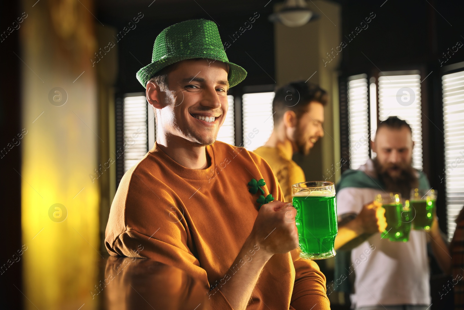 Photo of Man with glass of green beer in pub. St. Patrick's Day celebration