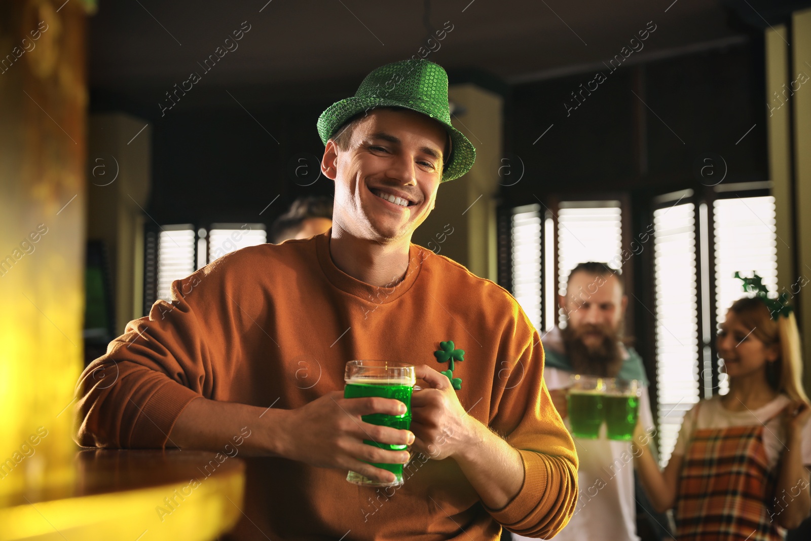 Photo of Man with glass of green beer in pub. St. Patrick's Day celebration