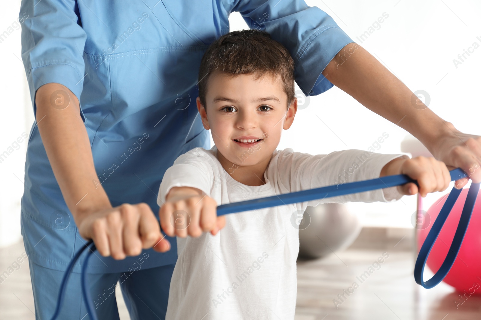 Photo of Orthopedist working with little boy in hospital gym