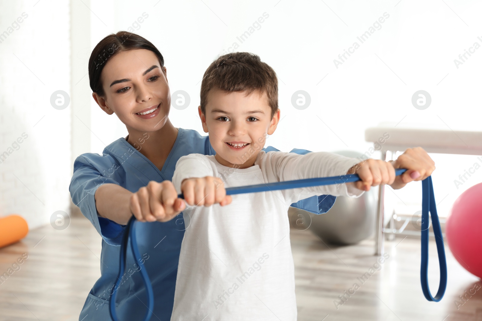 Photo of Orthopedist working with little boy in hospital gym