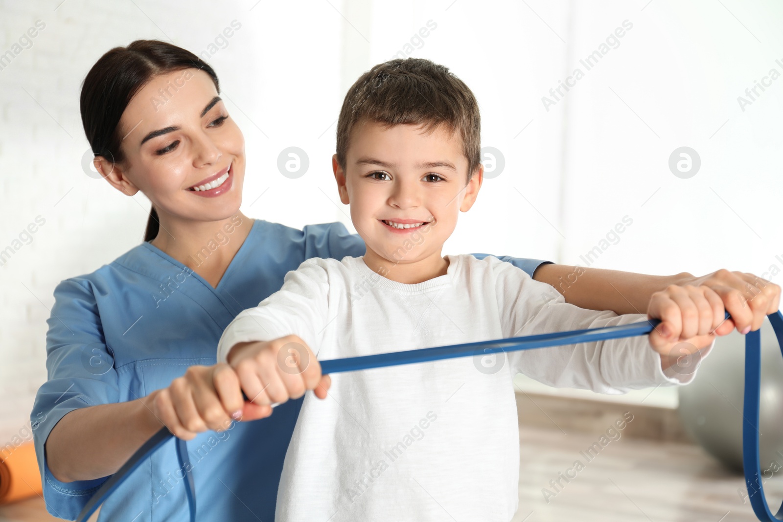 Photo of Orthopedist working with little boy in hospital gym