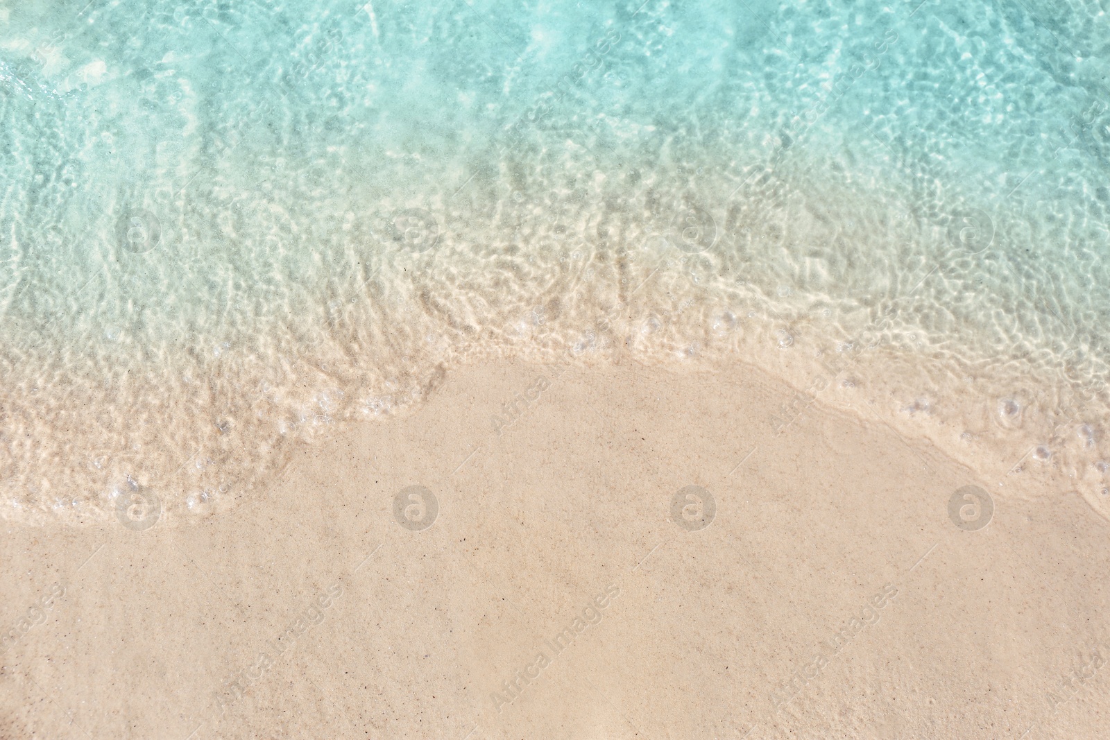 Photo of Sea waves rolling on beautiful sandy beach, top view. Summer vacation