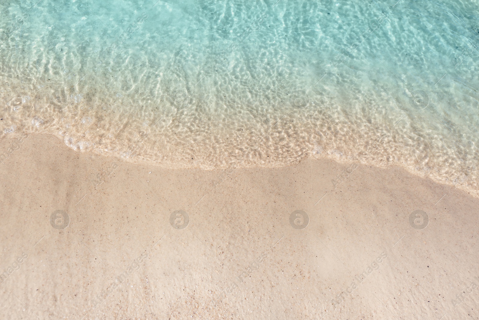 Photo of Sea waves rolling on beautiful sandy beach, top view. Summer vacation