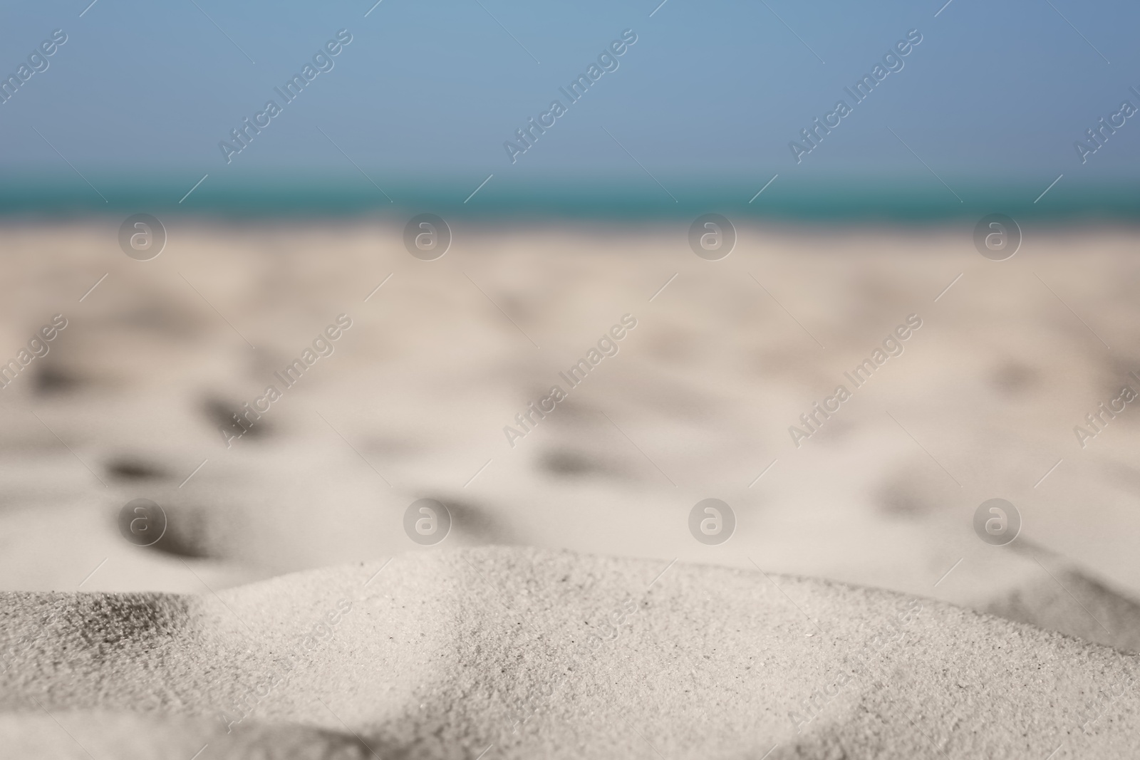 Photo of Beautiful sandy beach and sea on sunny day, closeup. Summer vacation