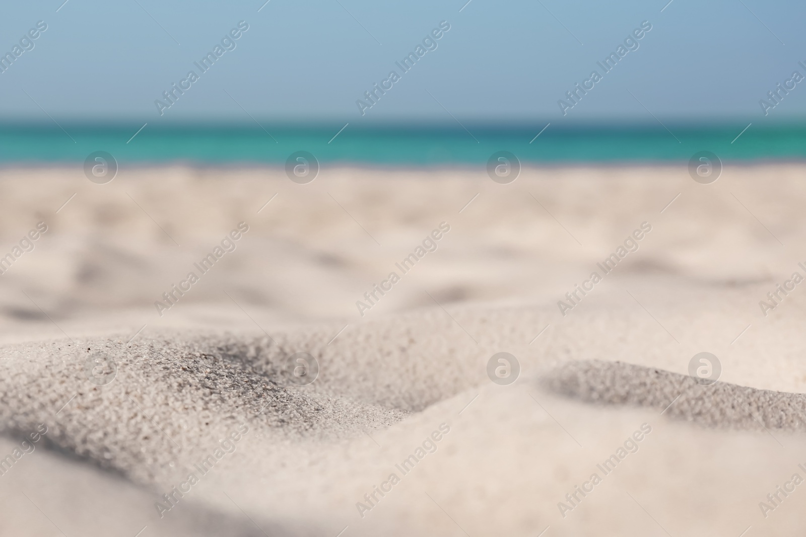 Photo of Beautiful sandy beach and sea on sunny day, closeup. Summer vacation