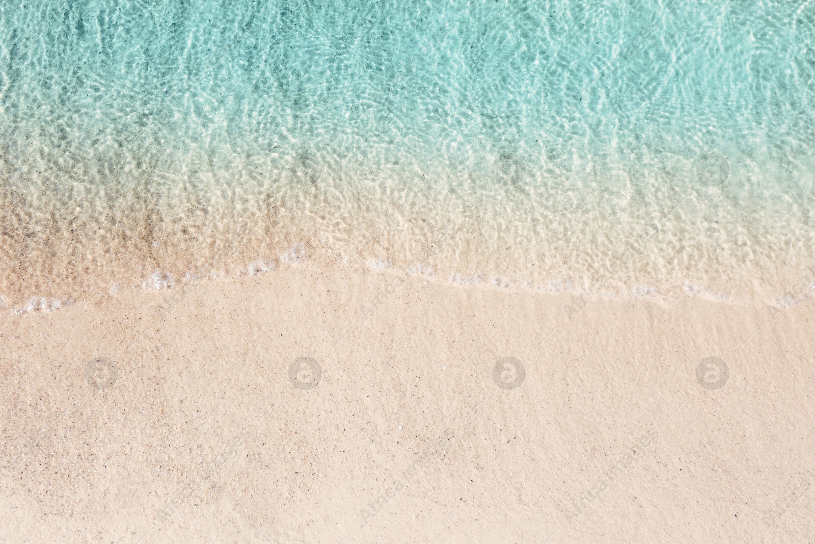 Photo of Sea waves rolling on beautiful sandy beach, top view. Summer vacation