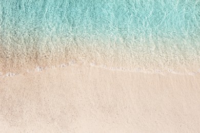 Photo of Sea waves rolling on beautiful sandy beach, top view. Summer vacation