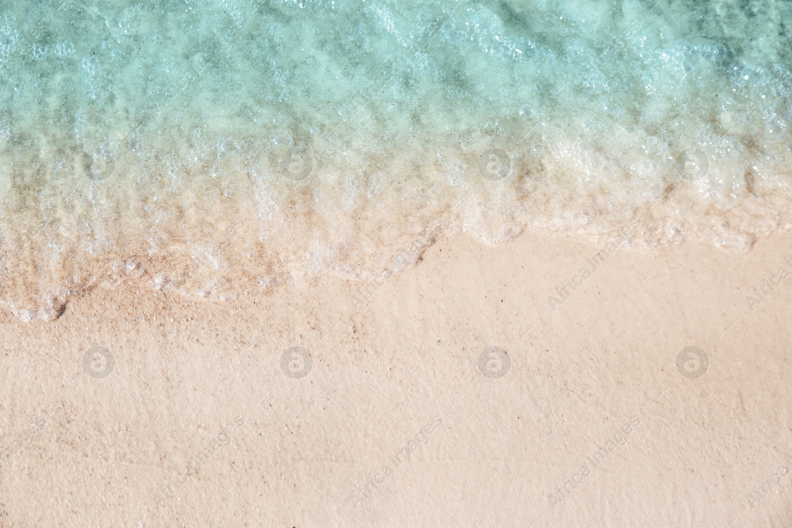 Photo of Sea waves rolling on beautiful sandy beach, top view. Summer vacation