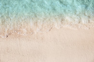 Sea waves rolling on beautiful sandy beach, top view. Summer vacation