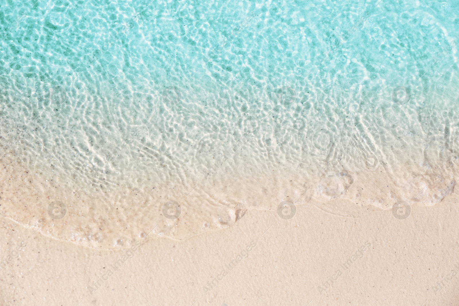 Photo of Sea waves rolling on beautiful sandy beach, top view. Summer vacation