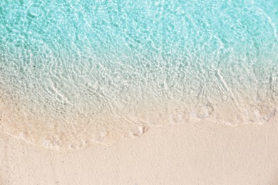 Photo of Sea waves rolling on beautiful sandy beach, top view. Summer vacation