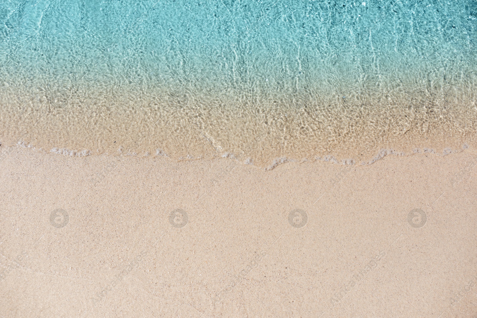 Photo of Sea waves rolling on beautiful sandy beach, top view. Summer vacation