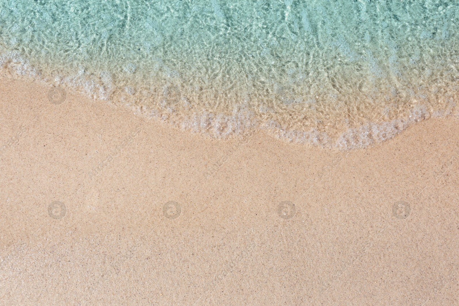 Photo of Sea waves rolling on beautiful sandy beach, top view. Summer vacation