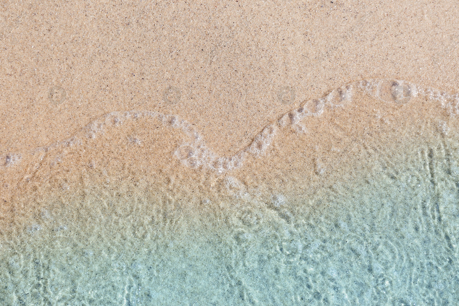 Photo of Sea waves rolling on beautiful sandy beach, top view. Summer vacation