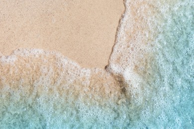 Photo of Sea waves rolling on beautiful sandy beach, top view. Summer vacation