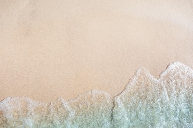 Photo of Sea waves rolling on beautiful sandy beach, top view. Summer vacation