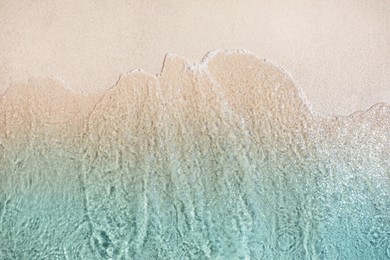 Sea waves rolling on beautiful sandy beach, top view. Summer vacation