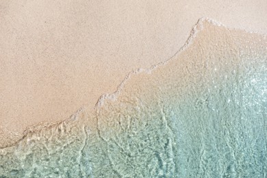 Photo of Sea waves rolling on beautiful sandy beach, top view. Summer vacation